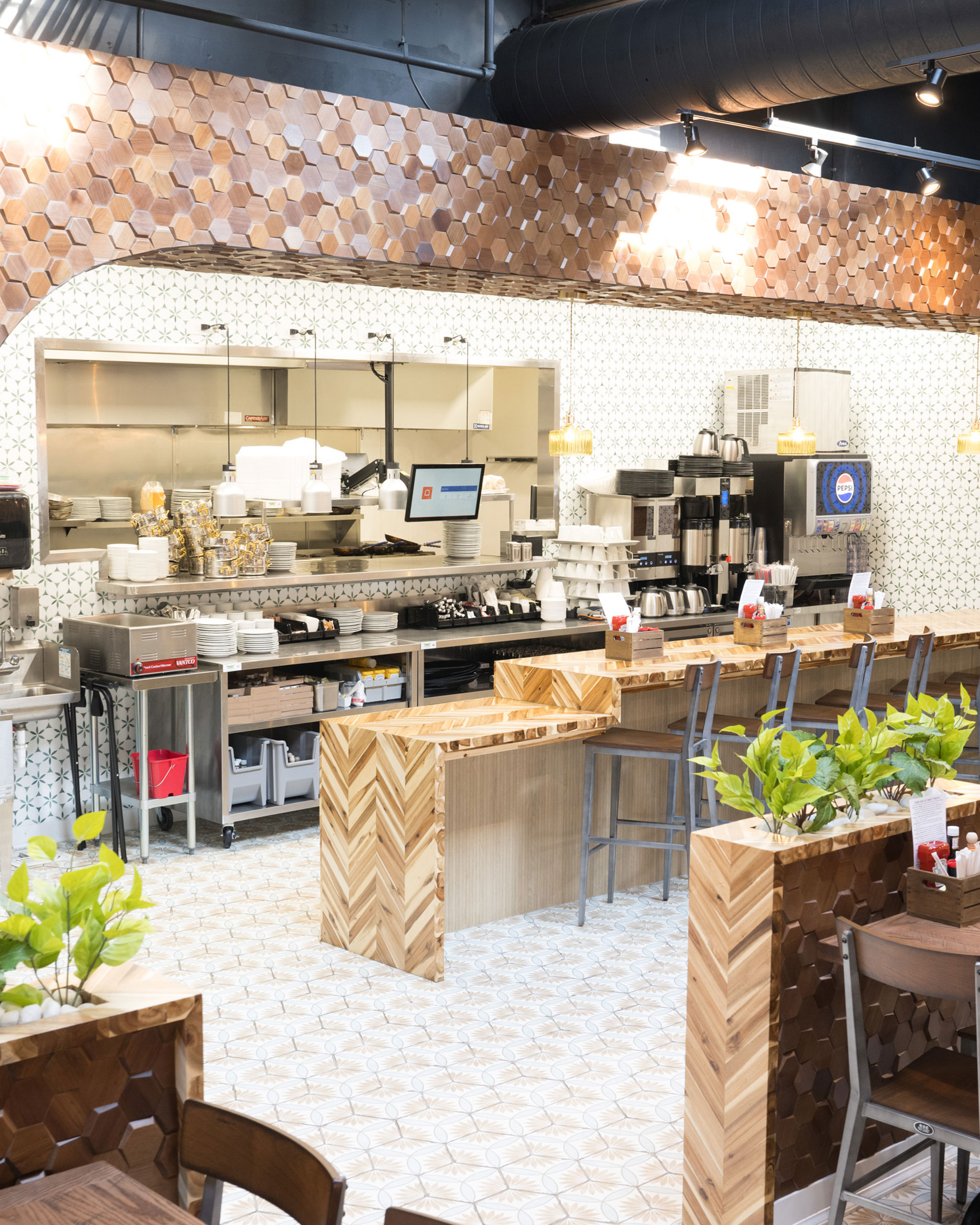 Open kitchen and counter seating at The White Sheep café in Naperville with wood accents and modern design.